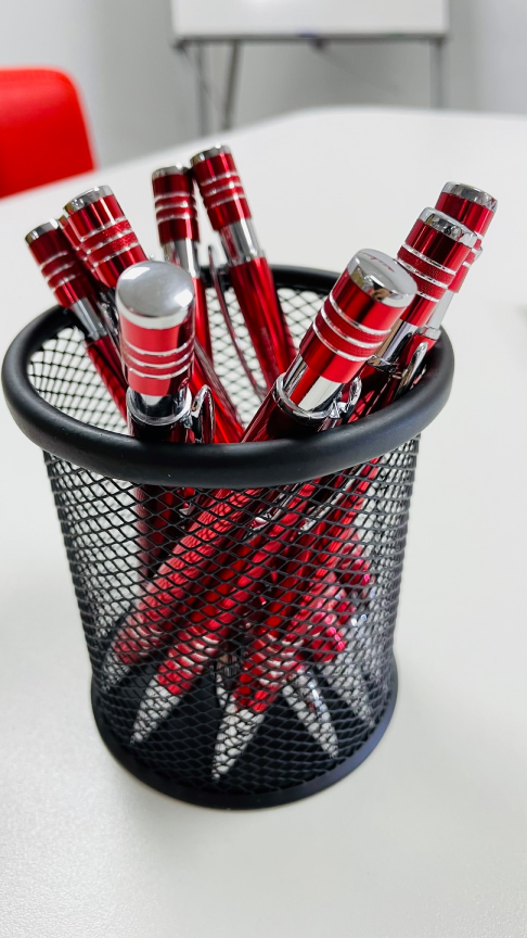 Red pens in black basket